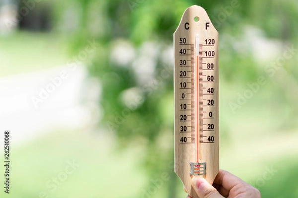 Fototapeta Close up hand holding thermometer with hot temperature