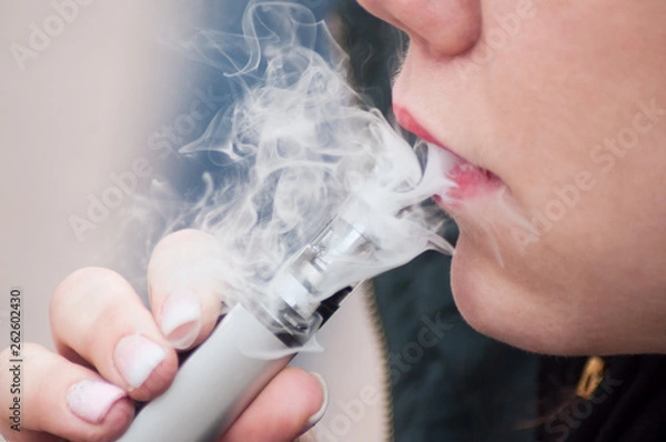 Obraz Closeup of mouth of woman with e-cigarette in outdoor