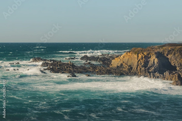 Fototapeta Waves crashing on the cliff and the rocks on Almograve beach