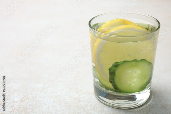 Fototapeta cup of  water with lemon and cucumber