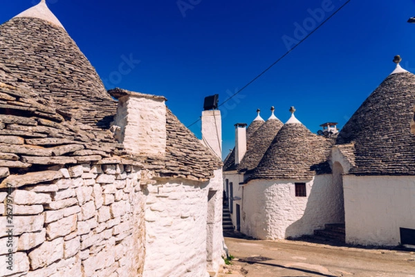 Fototapeta Beautiful single-storey houses of rounded construction called trulli, typical of the area of Alberobello in Italy.
