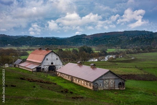Fototapeta country barns in farmland with river and beautiful sky