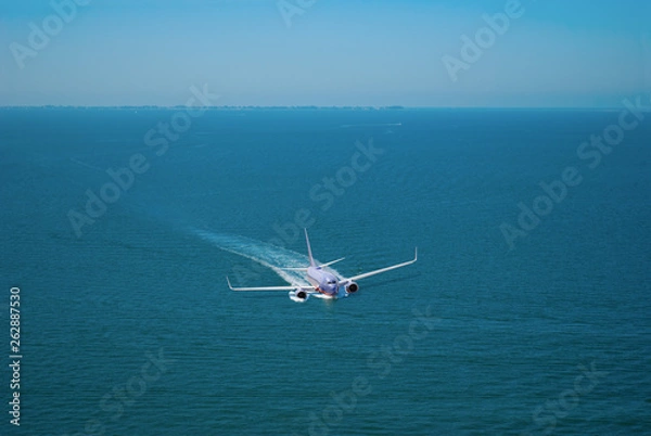 Fototapeta A large passenger jet plane airliner making an emergency crash landing on water trying to save everyone on the airplane and keep from sinking before being rescued.
