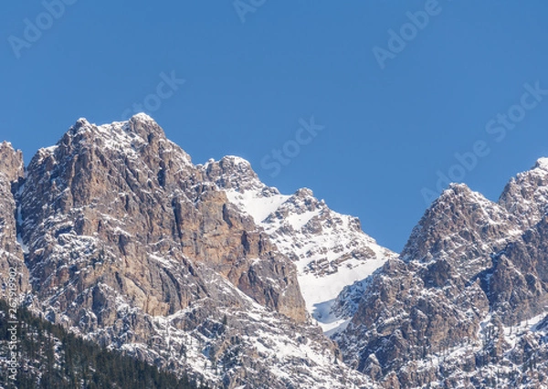 Fototapeta view of rocky mountains on a sunny spring day with clear blue sky.
