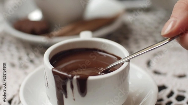 Obraz hand mixing chocolate in a hot milk, preparing hot chocolate or cacao, bautiful soft focus shot
