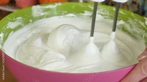 Obraz Kitchen mixer whips cream custard pastry whisk rotates rapidly. Food processor beat the eggs white egg whites into a thick foam. Kitchen machine in operation.