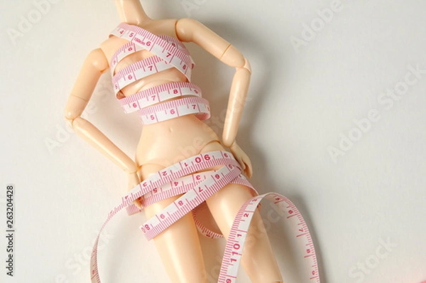 Fototapeta ドールにテープメジャーを巻いている