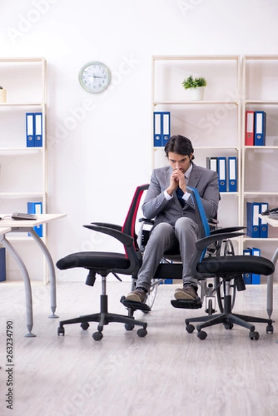 Obraz Young handsome employee in wheelchair working in the office  