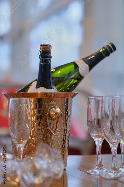 Fototapeta Bottle of champagne in bucket of ice. Bar counter.