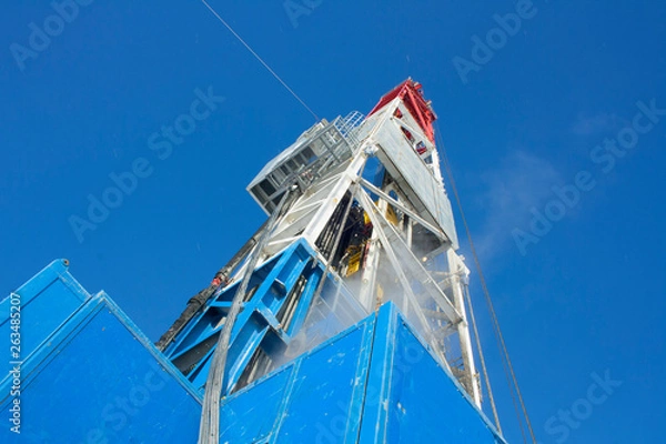 Fototapeta Drilling rig in Siberia bottom-up view. Winter.