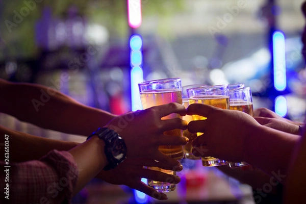 Fototapeta Group of  young people hands toasting and cheering aperitif beers half pint