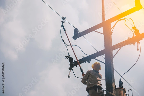Fototapeta The power lineman use clamp stick (insulated tool) to closing a transformer on energized high-voltage electric power lines. The power lineman must be trained because it is a risky job.