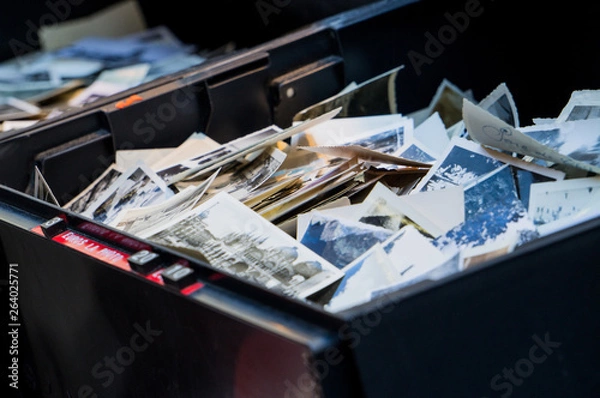 Fototapeta Pile of old vintage printed photos in a black box for sale 