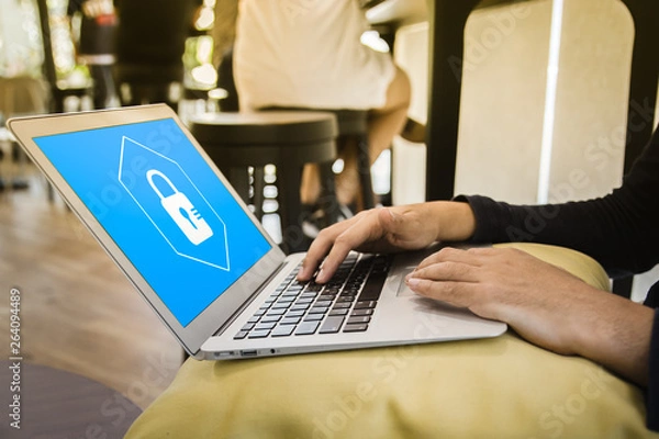 Fototapeta Business man working at a coffee shop with a laptop. elect the icon security on the virtual display.