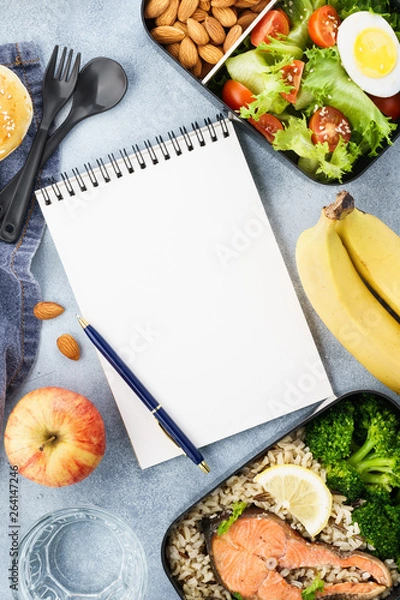 Fototapeta Healthy diet lunch boxes with food and empty notepad.