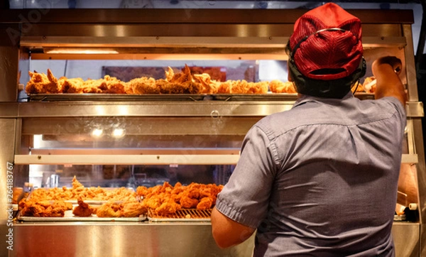 Fototapeta Minimum Wage Employee Works in a Fast Food Kitchen.