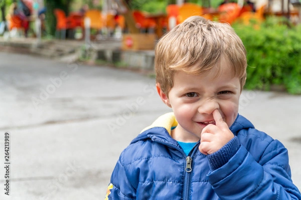Obraz Small child picking his nose and making faces