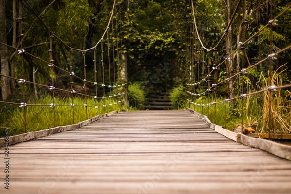 Obraz Bridge sling wooden floor, the bridge using a sling attached to the pole both sides and Use lath do the floor walkway is located In the midst of nature.