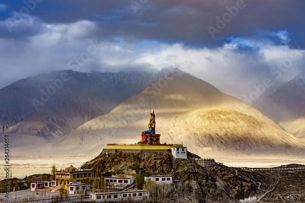 Fototapeta The Maitreya Buddha statue with Himalaya mountains in the background from Diskit Monastery or Diskit Gompa, Nubra valley, Leh Ladakh, Northen India.