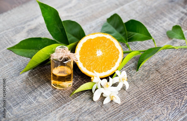 Obraz Juicy Orange cięta na dwie części oraz neroli, kwiaty drzewa pomarańczy, na rustykalnym tle drewna. Kwiat pomarańczy to pachnący kwiat cytrusów, używany w perfumach i herbacie, afrodyzjak.