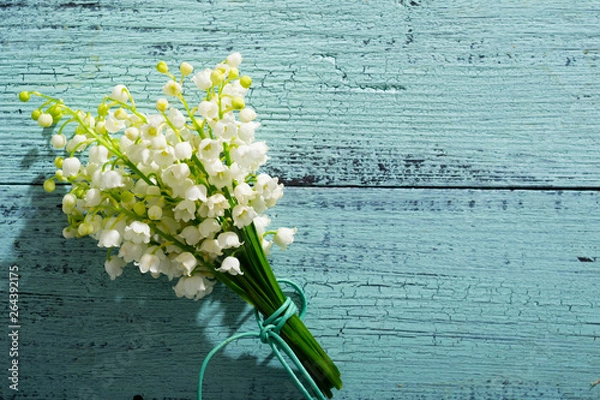 Obraz Lily of the valley flowers on cracked blue wood table background, directly above