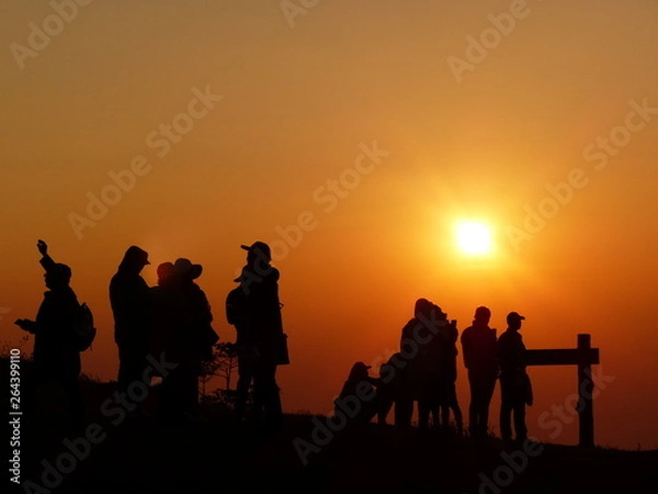 Fototapeta Silhouette of many tourists watching sunrise in viewpoint on mountain