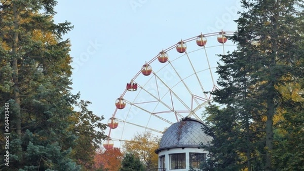 Obraz Ferris wheel rotates in a park in the foreground roof observatory