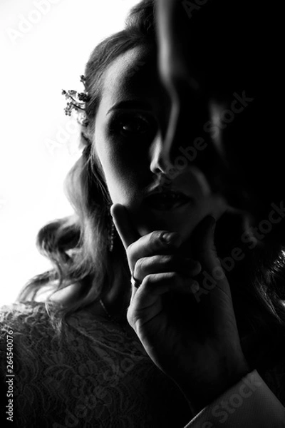 Fototapeta Closeup portrait of bride and groom. A man holds a beautiful girl by the chin