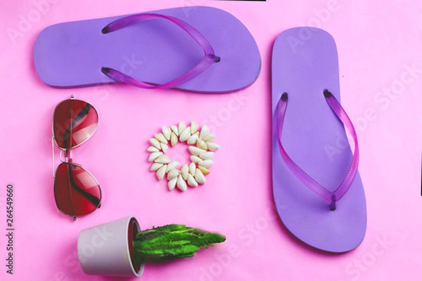 Fototapeta Beach purple flip flops, aviator sunglasses, seashell bracelet and succulent cacti cactus on a pink background. Summer vacation colorful travel beach flat lay