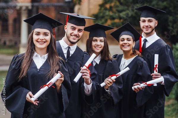 Fototapeta Happy graduates. Five college graduates standing in a row and smiling. Nice time!