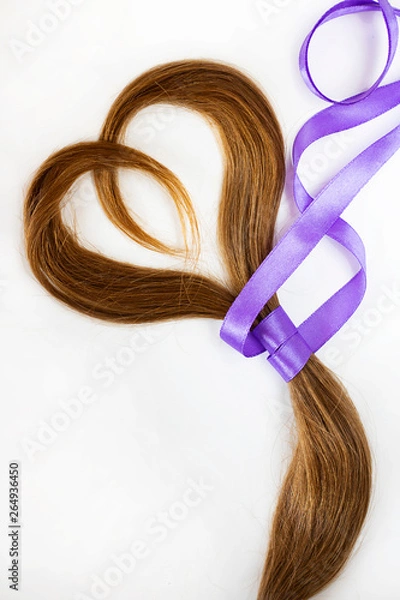 Fototapeta long blond hair donation put like heart with lavender ribbon as symbol of fight against cancer on white background. Top view. Natural material for making wig for patients. Vertical, isolated. Concept