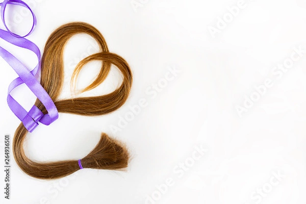 Fototapeta long blond hair donation put like heart with lavender ribbon as symbol of fight against cancer on white background. Top view. Natural material for making wig for patients. Horizontal isolated. Concept