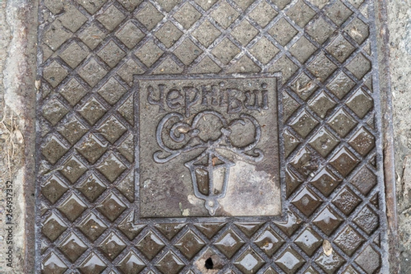 Fototapeta Close up of hatch (luke) in Chernivtsi, Ukraine. Metal rusty manhole cover in Bukovina, Eastern Europe. Grunge and texture concept. Translation: "Chernivtsi" (name of the city)