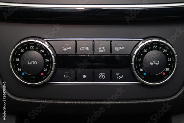 Obraz Rear central console on the panel inside the car close-up with climate control and seat heater buttons in gray and black. Auto service industry. Comfort concept.