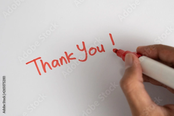 Fototapeta gesture of hand writing thank you on white paper