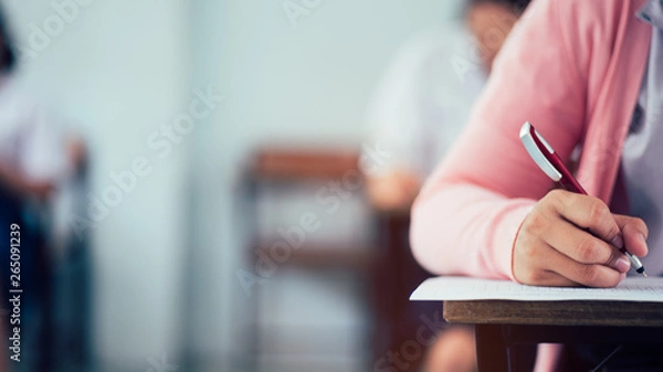 Fototapeta Hand of students writing and taking exam with stress in classroom