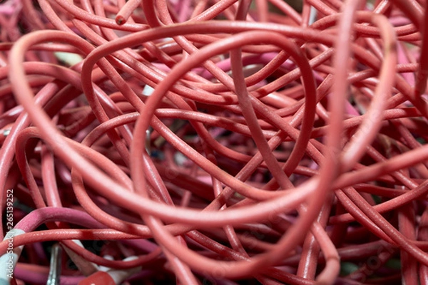Fototapeta A large pile of highly entangled red electrical wires. Mess, chaos, confusion. A lot of twisted and curved cables.