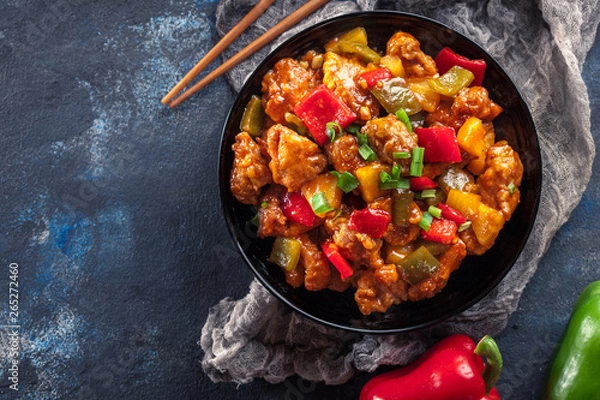Fototapeta Sweet and sour chicken with colorful bell pepper on a plate