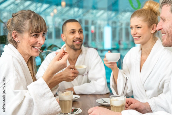 Obraz junge Leute Gruppe trinken Kaffee, Cappuccino und Sekt in einer Wellnesslandschaft Schwimmbad. Sie tragen einen weißen Bademantel in der Sauna