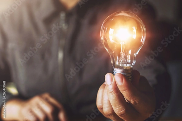 Obraz ręka trzymająca żarówkę. koncepcja pomysłu z innowacjami i inspiracją