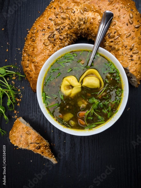 Fototapeta Hot sorrel and spinach soup with bread and dumplings on wooden background.