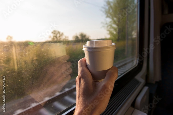 Obraz Hand holding coffe cup on train