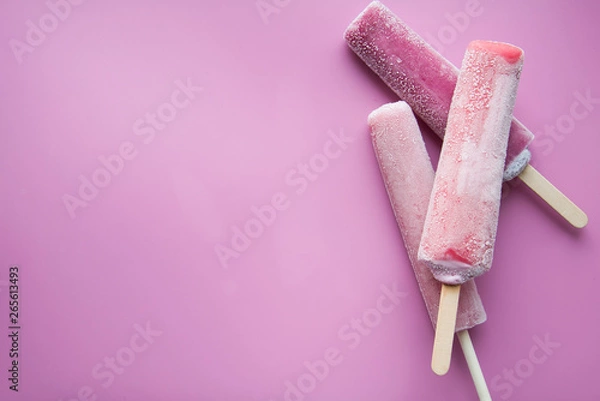 Fototapeta Bright fruit ice cream on a stick on a pink background. Frozen fruit ice. Summer mood. Cooling dessert in hot weather. Favorite delicacy for children. Homemade raspberry, strawberry, watermelon ice