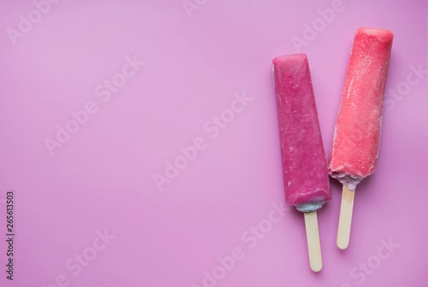 Fototapeta Bright fruit ice cream on a stick on a pink background. Frozen fruit ice. Summer mood. Cooling dessert in hot weather. Favorite delicacy for children. Homemade raspberry, strawberry, watermelon ice