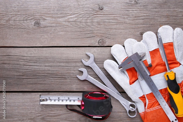 Fototapeta Different construction tools on grey wooden background with copy space.