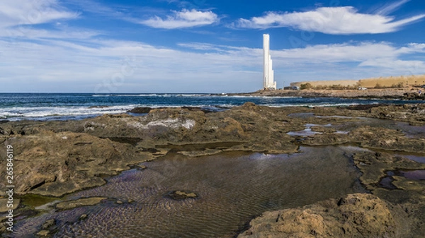 Obraz White lighthouse on the rocky coast