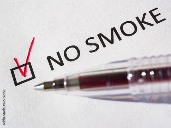 Fototapeta Questionnaire. Red pen and the inscription NO SMOKE with check mark on the white paper. Close-up background. High-quality macro photography.