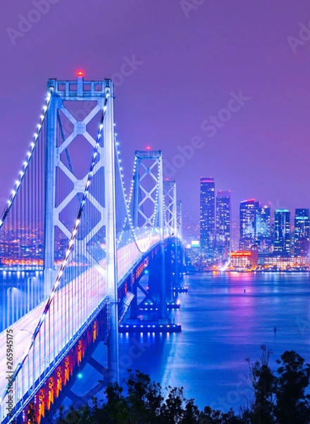 Obraz View of Bay Bridge across San Francisco Bay with lots of cars passing through in San Francisco at night.