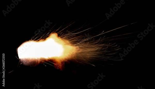 Fototapeta Texture of firearm shot with bright flash of light, sparks, smoke and gunpowder gases on black background