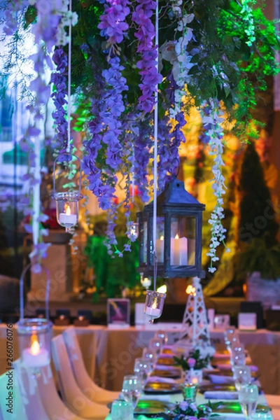 Fototapeta Vines with Hanging Lanterns Floating over an Elegant Dinner event.